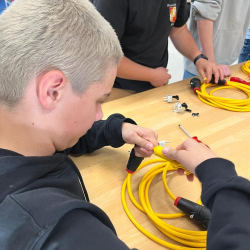 Schüler probiert sich beim Spitzen von Kabeln