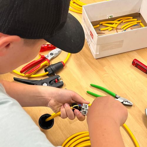 Schüler probiert sich beim Spitzen von Kabeln