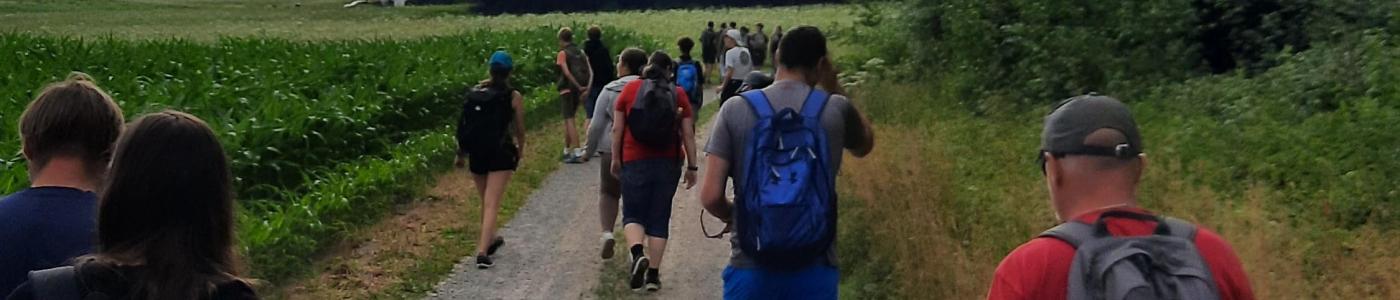 Leherer und Schüler:innen am Feldweg