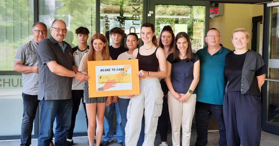 Schüler:innen bei der Übergabe des Spendenschecks