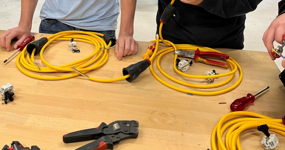 Schüler probiert sich beim Spitzen von Kabeln